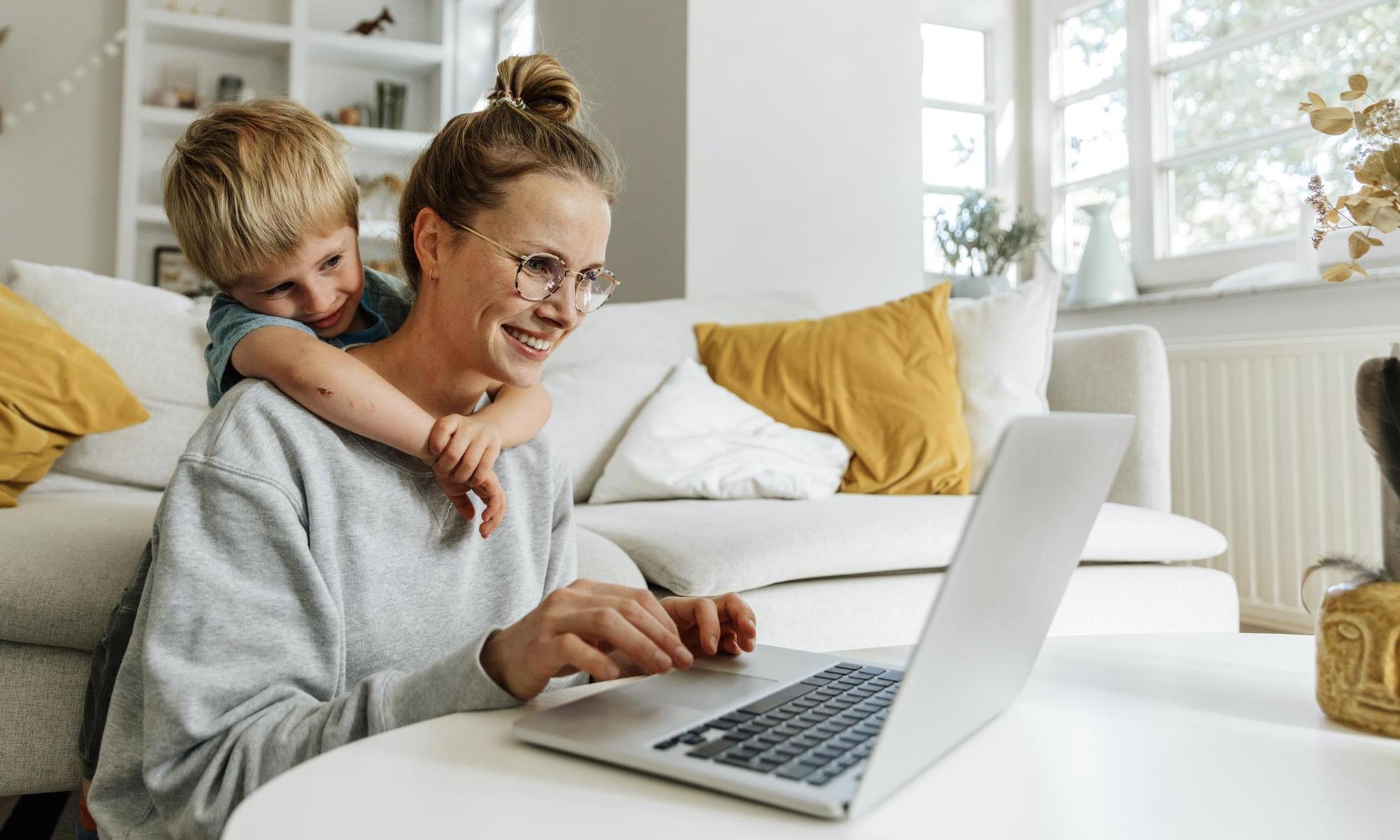 Mother and child using a laptop together in their living room